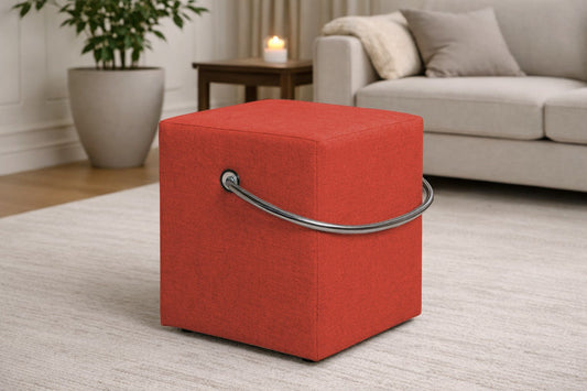 OrangefarbenerPolsterhocker mit Griff im modernen Wohnzimmer, leichter Sitzhocker auf hellem Teppich vor Sofa und Beistelltisch.– Handgefertigte Polsterhocker