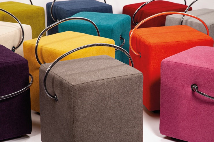 Polsterhocker in verschiedenen Farben mit integriertem Tragegriff – moderne Designhocker als flexible Sitzlösung für Wohn- und Arbeitsbereiche