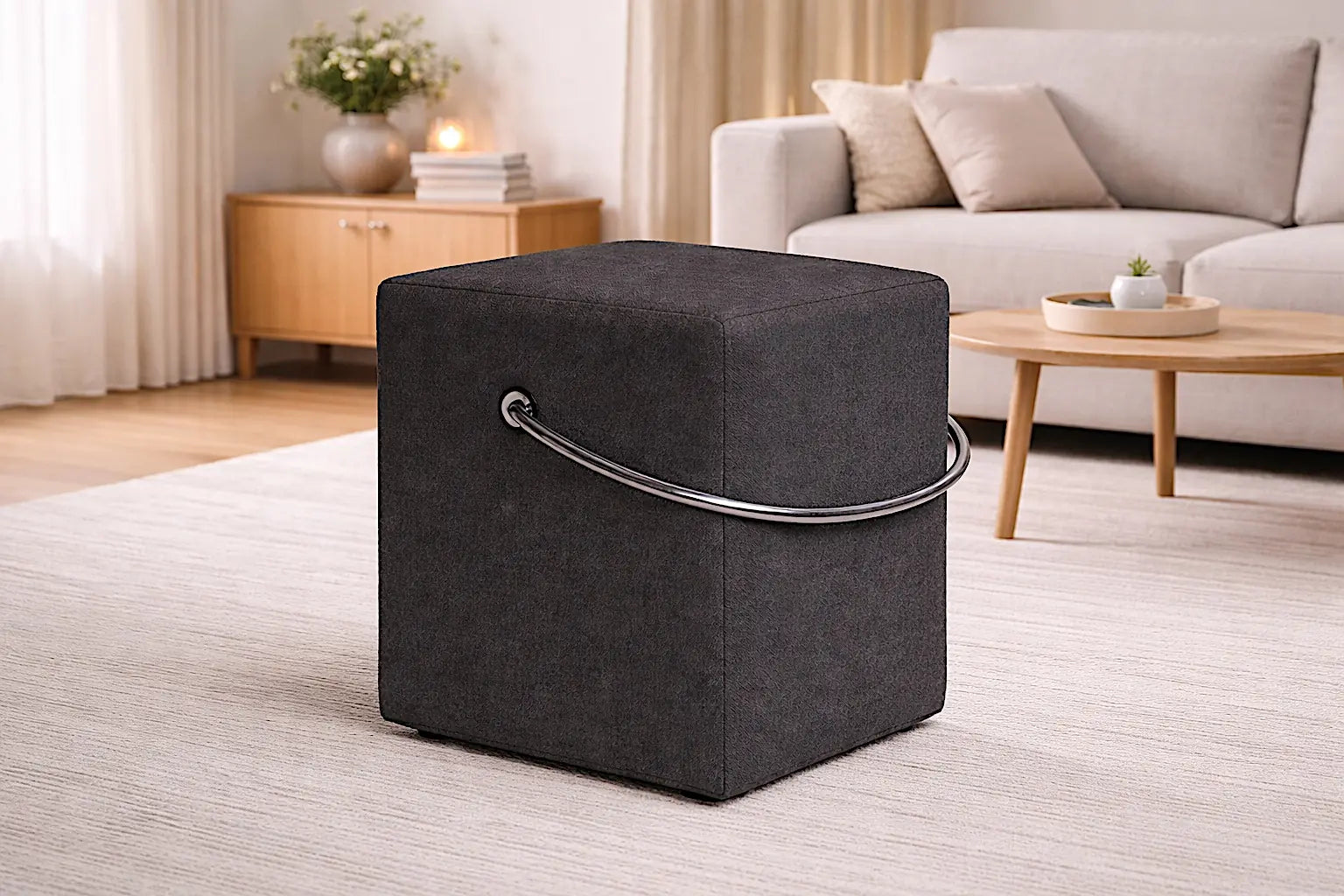 Anthrazitfarbener Polsterhocker mit Tragegriff im modernen Wohnraum