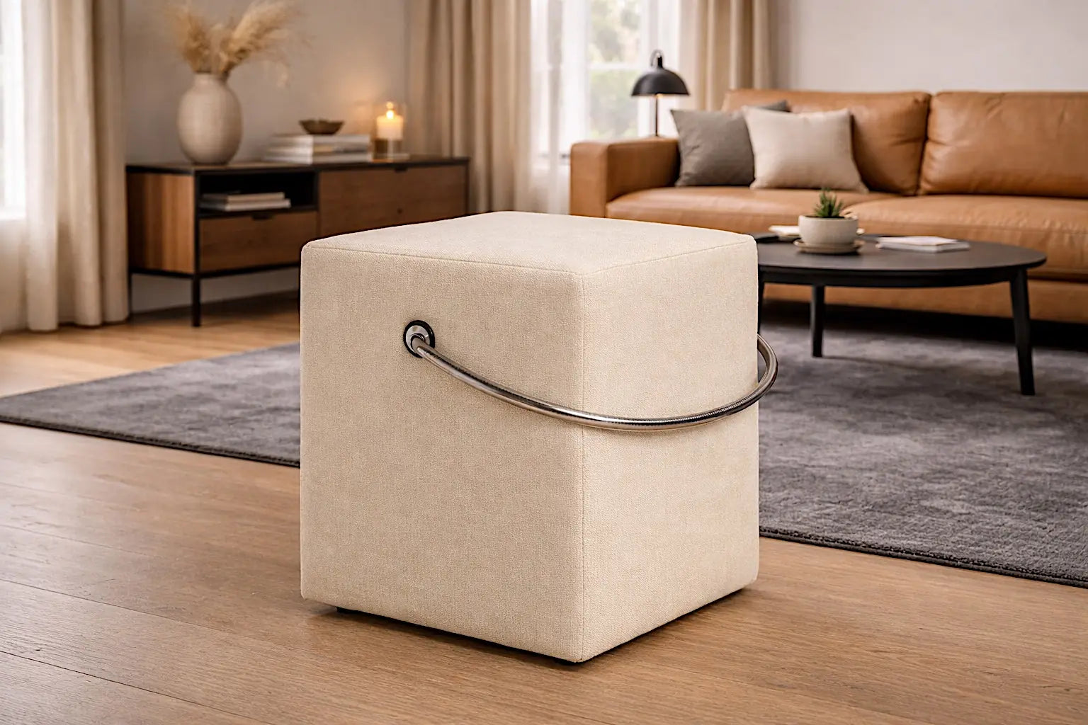 Beigefarbener Polsterhocker mit Tragegriff im modernen Ambiente