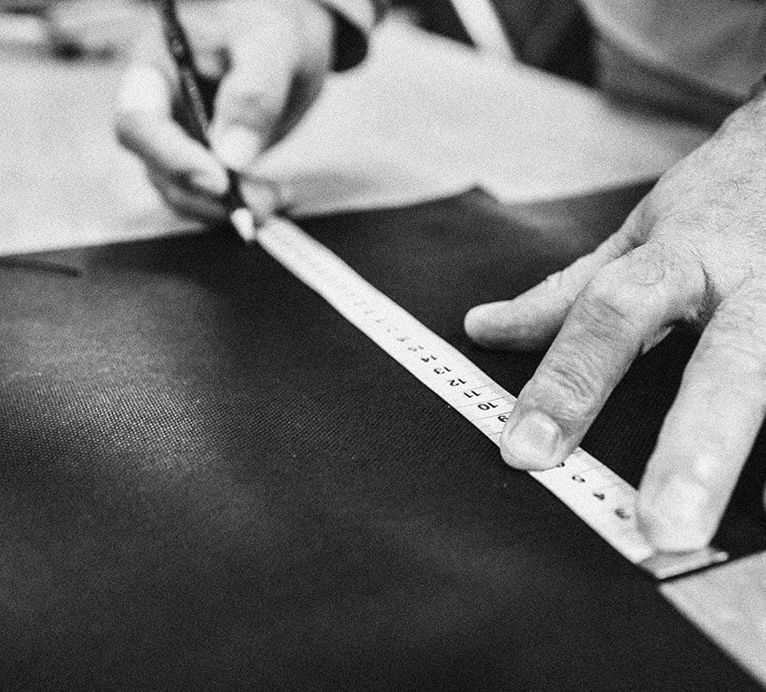 Handwerk in der Hockerhelden Manufaktur – präzises Zuschneiden von Stoffen mit Maßband