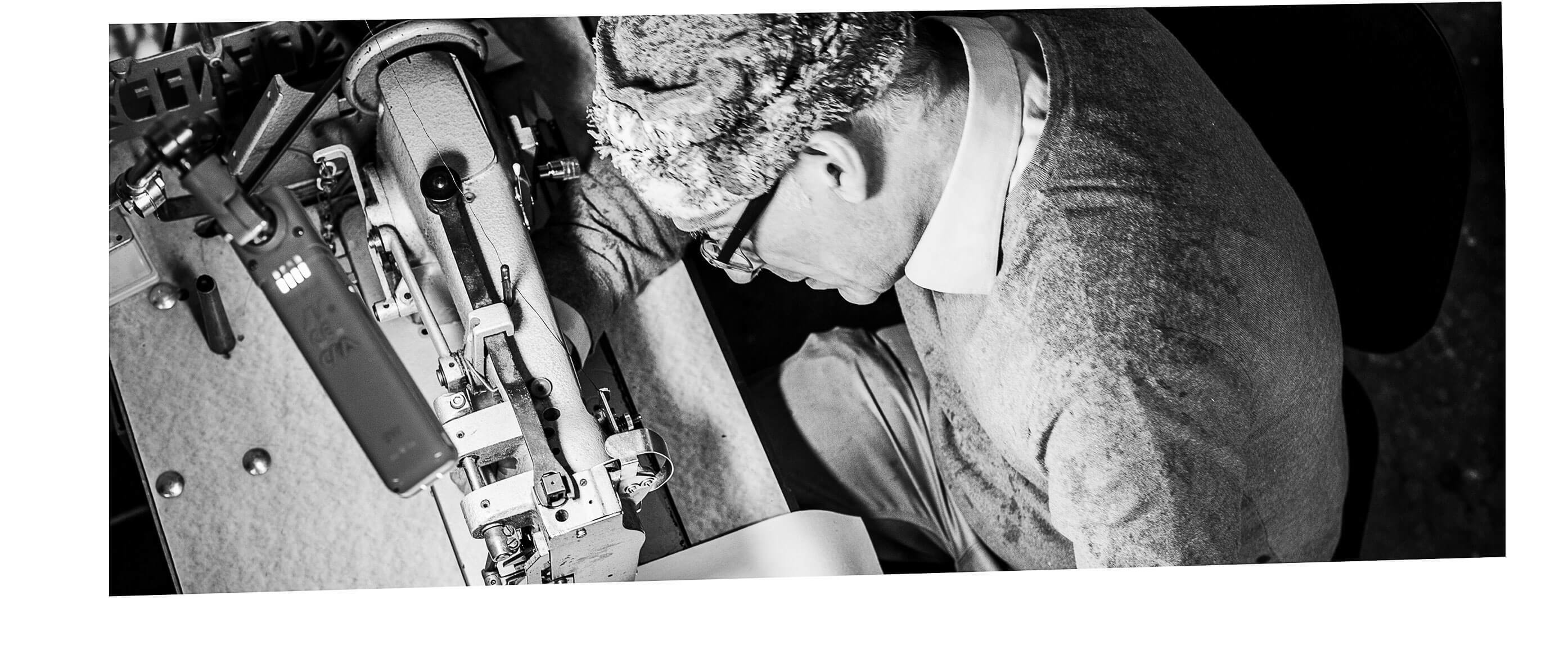 Handwerker an der Nähmaschine in der Hockerhelden Manufaktur – sorgfältige Polsterarbeit