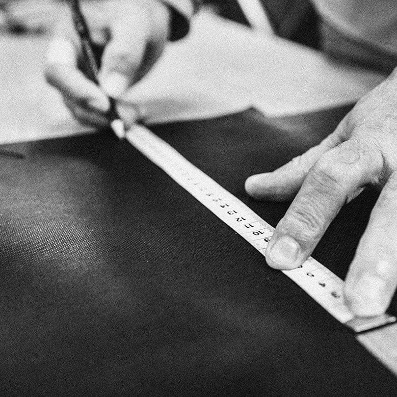 Präzises Zuschneiden von Stoffen mit Maßband in der Hockerhelden Manufaktur