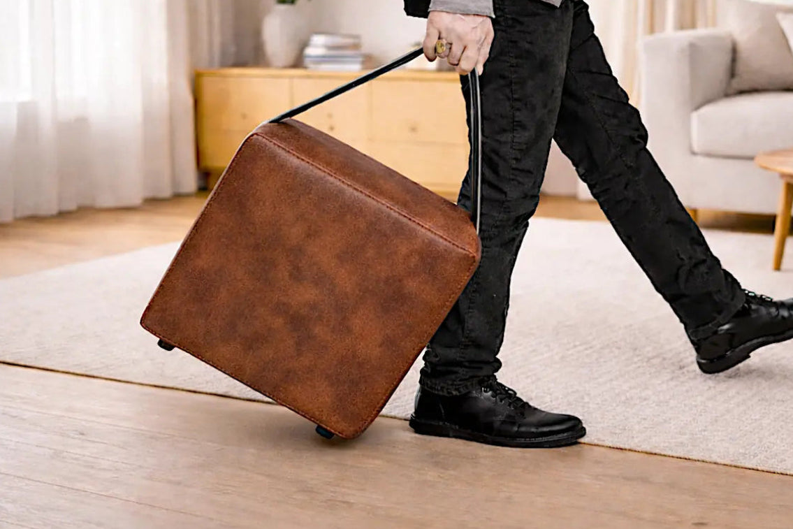 Polsterhocker mit Tragegriff wird von einer Person mühelos getragen