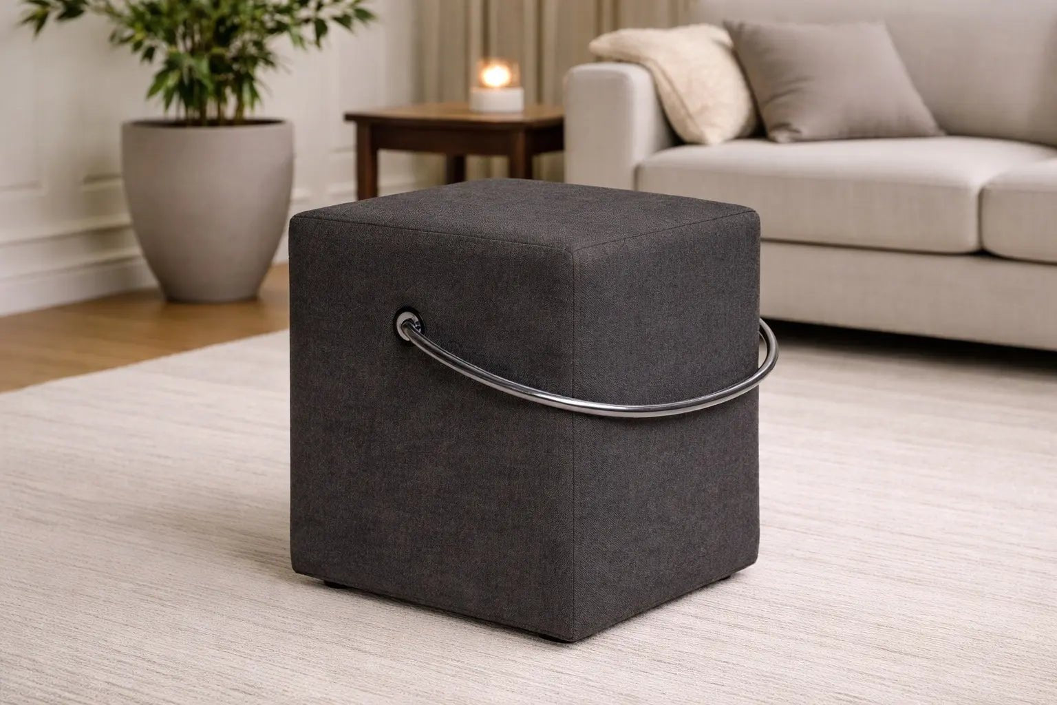 Anthrazitfarbener Polsterhocker im Wohnzimmer – tragbarer Hocker neben Sofa