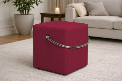 Roter Polsterhocker mit Griff im modernen Wohnzimmer, leichter Sitzhocker auf hellem Teppich vor Sofa und Beistelltisch.– Handgefertigte Polsterhocker