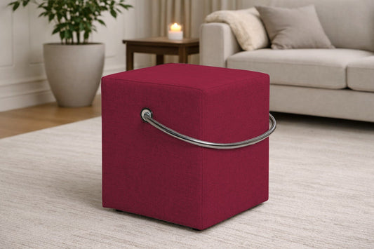 Roter Polsterhocker mit Griff im modernen Wohnzimmer, leichter Sitzhocker auf hellem Teppich vor Sofa und Beistelltisch.– Handgefertigte Polsterhocker