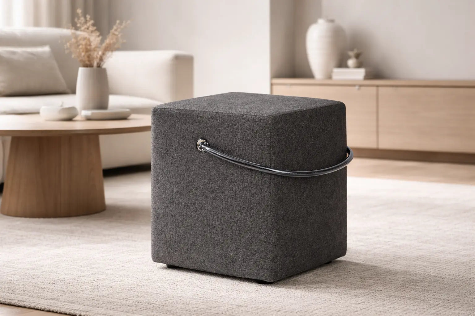 Polsterhocker in Anthrazit mit Tragegriff in einem modernen Wohnhambiente
